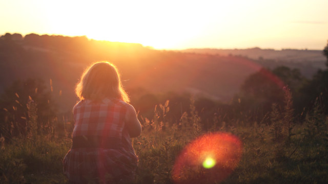 ein MÃ¤dchen, das den Sonnenuntergang beobachtet